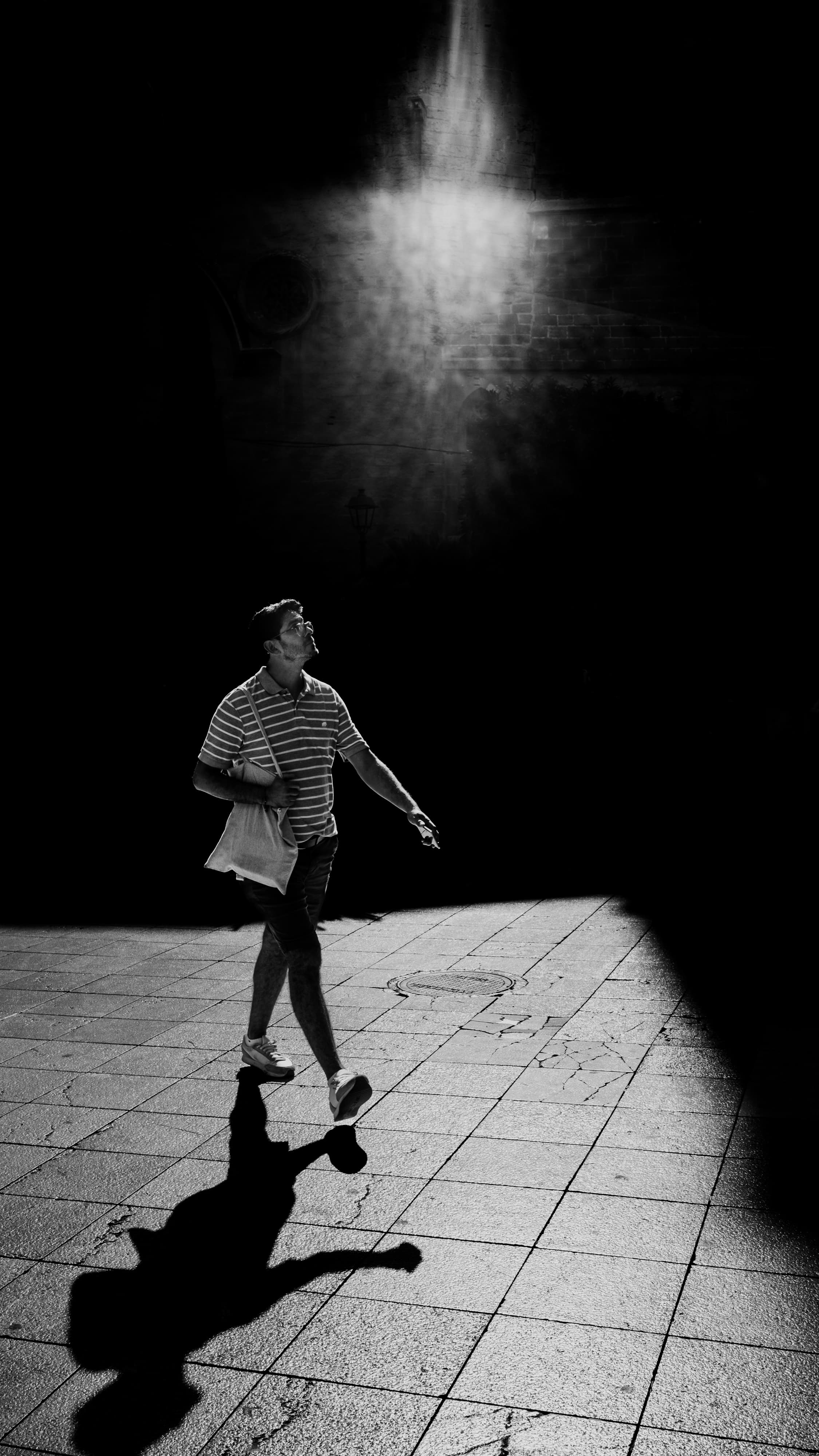Walking figure under a single ray of light