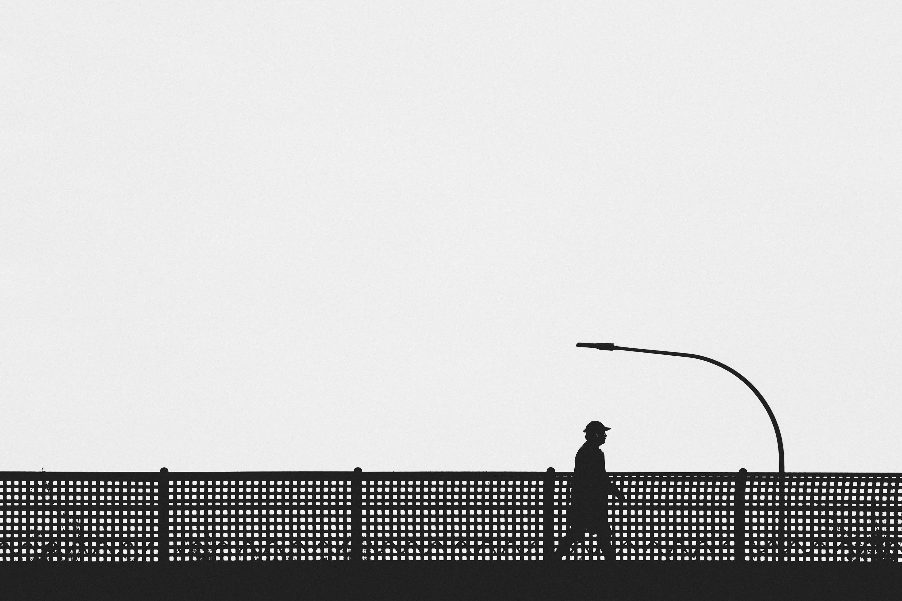 Man with hat walking along a bridge railing, Palma de Mallorca