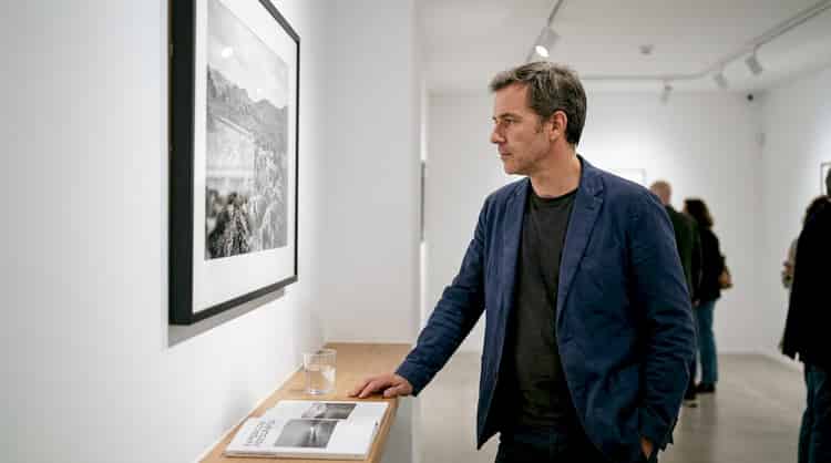 Un hombre contempla un retrato en una sala de exposiciones.