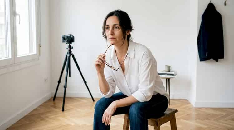 Mujer absorta en sus pensamientos, sentada en un estudio fotográfico